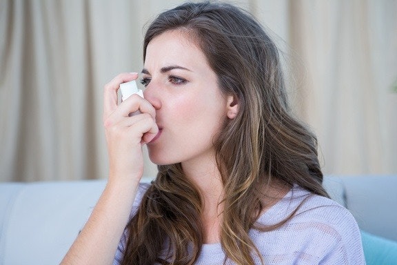 Woman Using Puffer from asthma triggers Air purifier