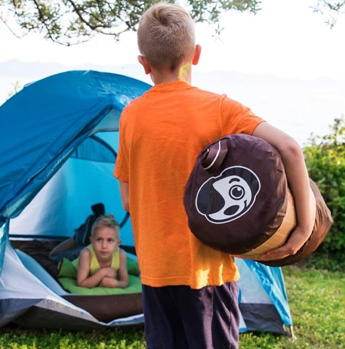 Boy carrying the Shrunks Outdoor bed for camping